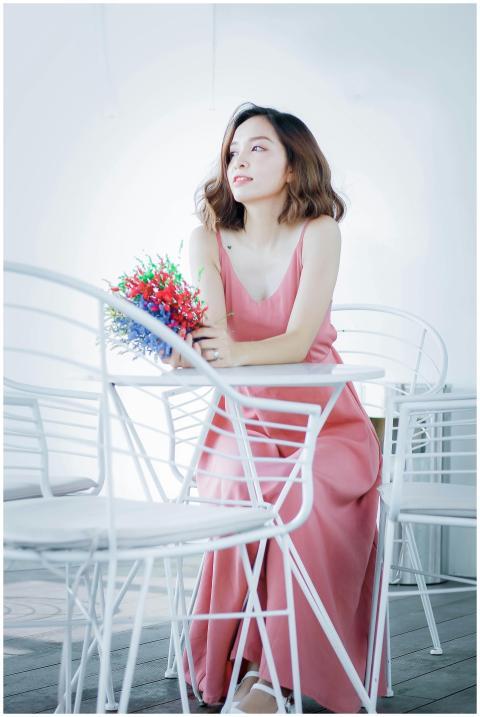 A woman in a pink dress holding colorful flowers w