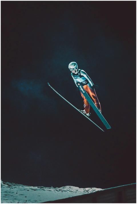 Dramatic night-time shot of a skier performing a s
