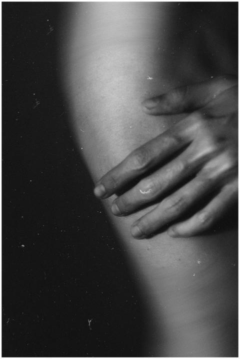 Close-up black and white image of a hand touching