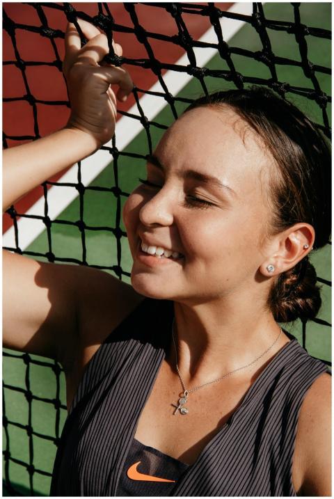 A young woman with closed eyes smiles joyfully bes