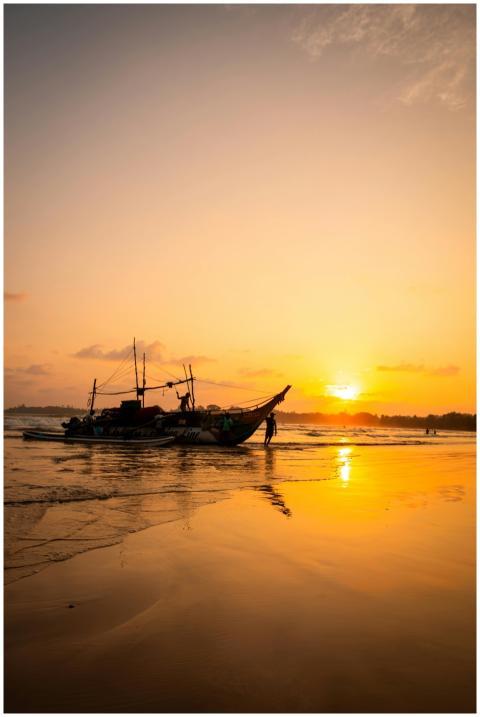 Silhouetted fishing boat at sunset on Weligama Bea