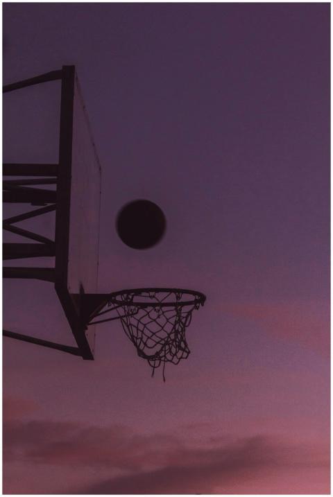 Silhouette of a basketball hoop and ball during tw