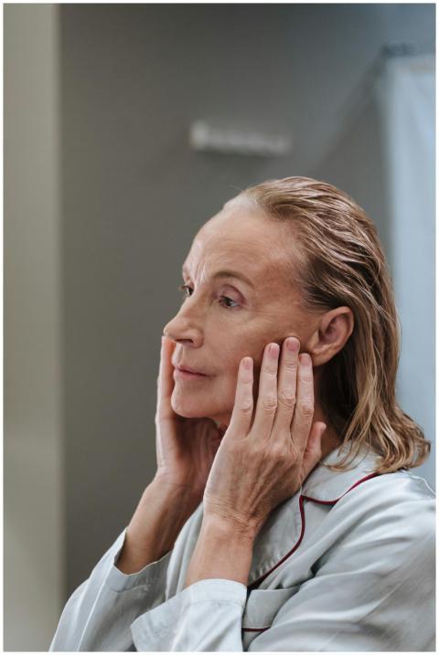 Senior woman applying skincare in the bathroom dur