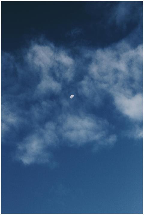 A serene night sky with the moon peeking through s