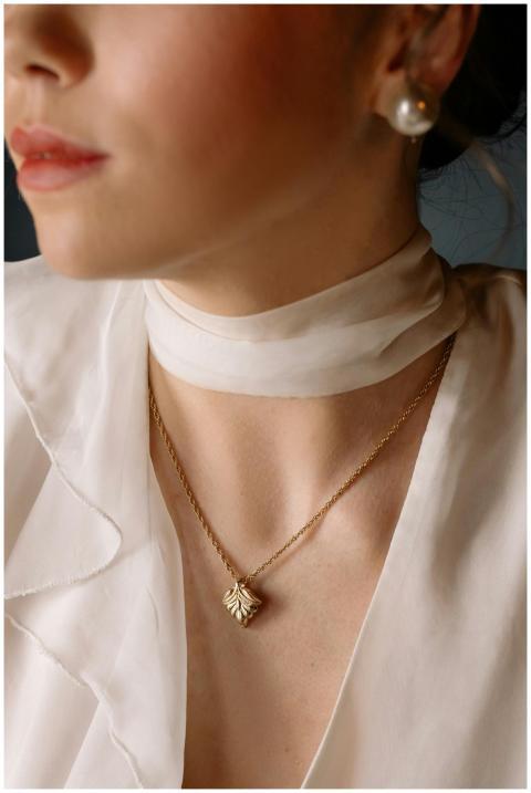 Close-up of a woman wearing a delicate gold pendan