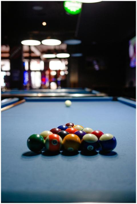 Colorful billiard balls arranged on a pool table i