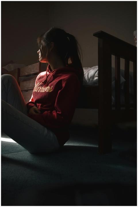 Contemplative young woman in hoodie sitting on the