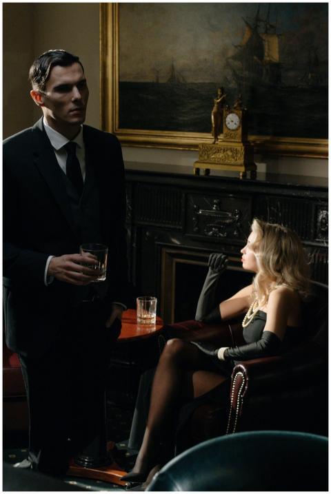 A stylish woman and man in a vintage lounge embrac