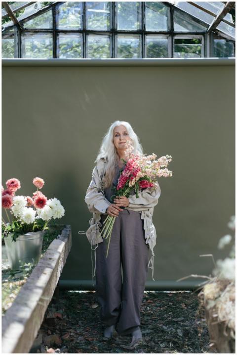 Senior woman with long hair holding a vibrant bouq