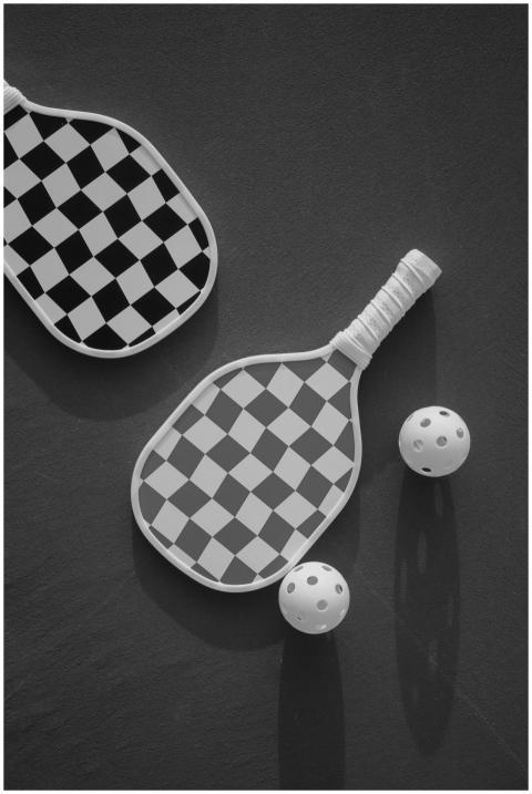 Stylish black and white checkered paddles and ball