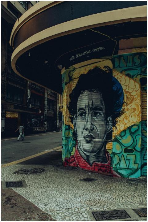 Colorful mural depicting a man's face on a street