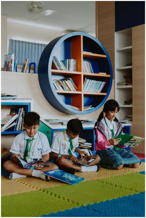 Children in school uniforms enjoy reading books in