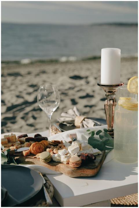 A beachfront picnic setup with cheese, food, and c