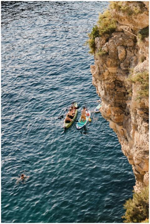 Aerial view of kayakers exploring the cliffside wa
