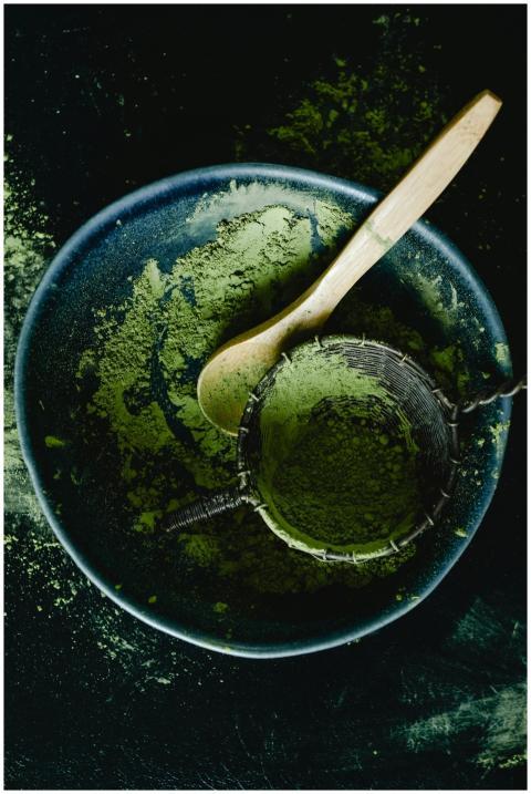 Overhead view of green matcha powder with a wooden