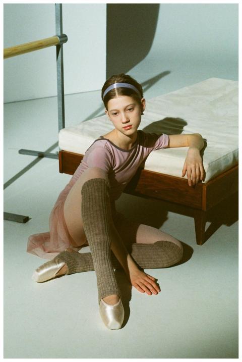 Ballet performer sitting in a studio, wearing poin
