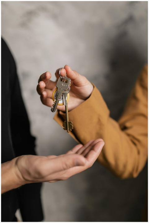 Two adults exchanging house keys, symbolic of prop