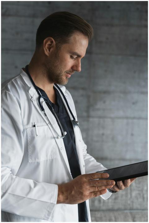 Portrait of a confident male doctor using a tablet