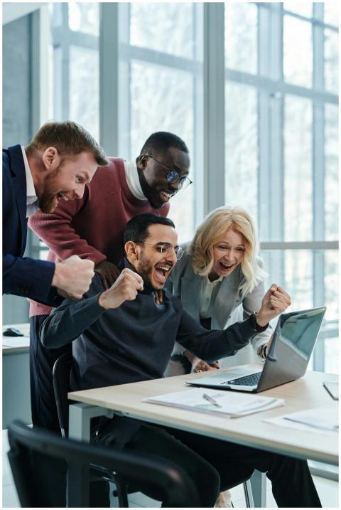 A diverse team in an office celebrates a successfu