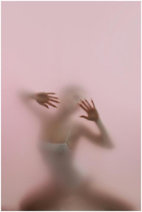Blurred silhouette of a woman posing behind froste