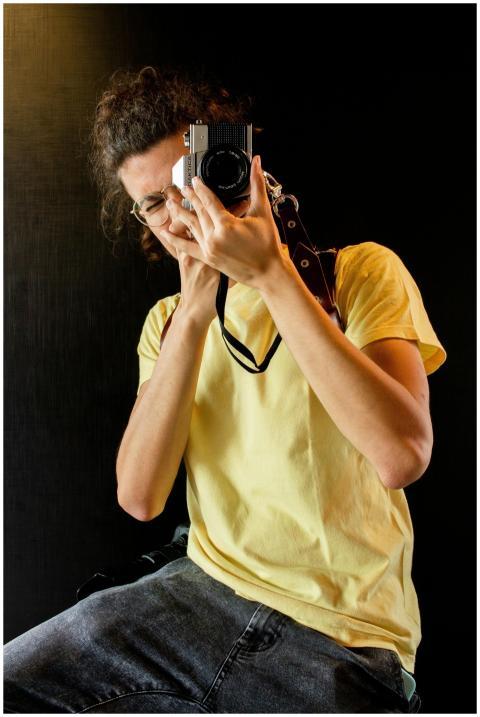 A young adult photographer wearing casual attire c
