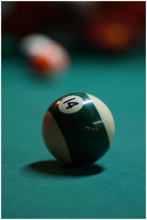 Focused shot of a number 14 billiard ball on a gre