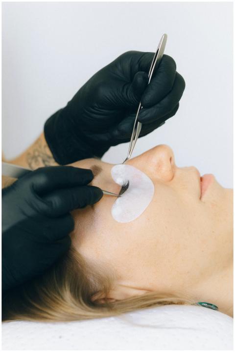 Close-up of a beautician applying eyelash extensio