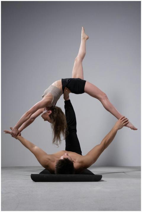 A man and woman perform an impressive acrobatic po