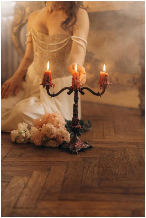 Elegant woman in a white dress touching a candelab