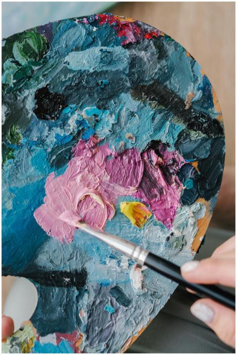An artist mixes vibrant colors on a palette with a