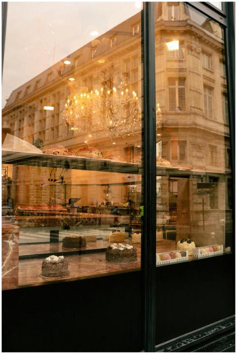 Elegant bakery window in Paris reflecting the city