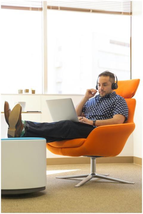 A man relaxes while working remotely in a modern o