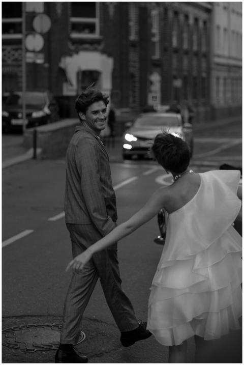 Bride and groom joyfully walking down a city stree
