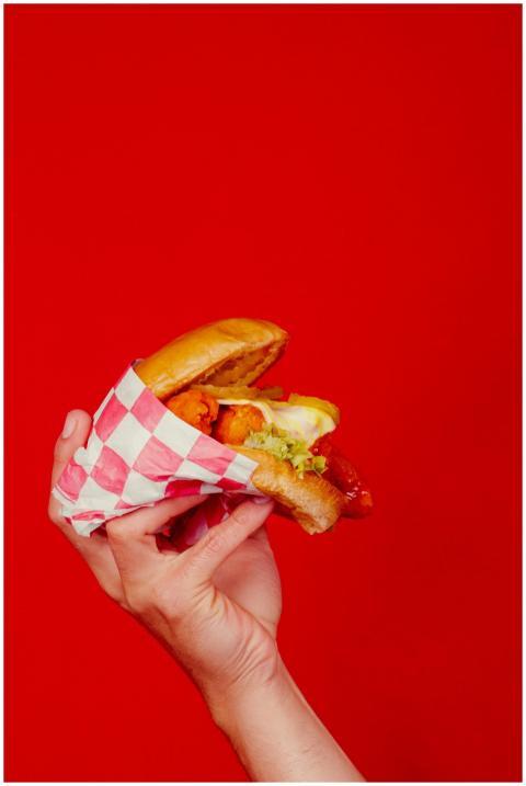 Vibrant close-up of a delicious burger held with a
