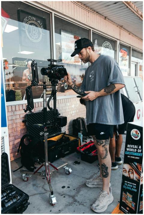 Videographer setting up camera gear outside a shop