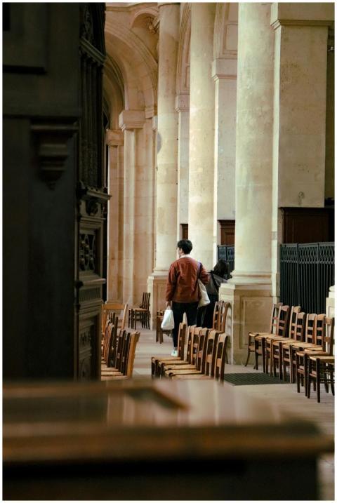 A lone person walks through a serene church interi