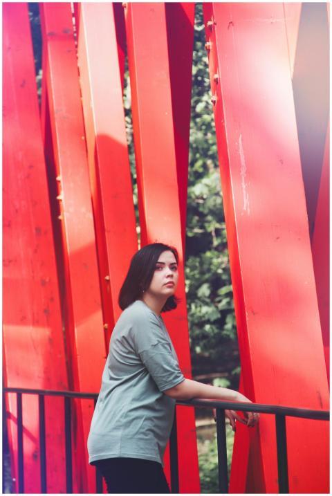 Portrait of a young woman on a striking red bridge
