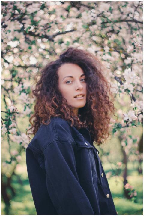 Portrait of a woman in a denim jacket standing amo