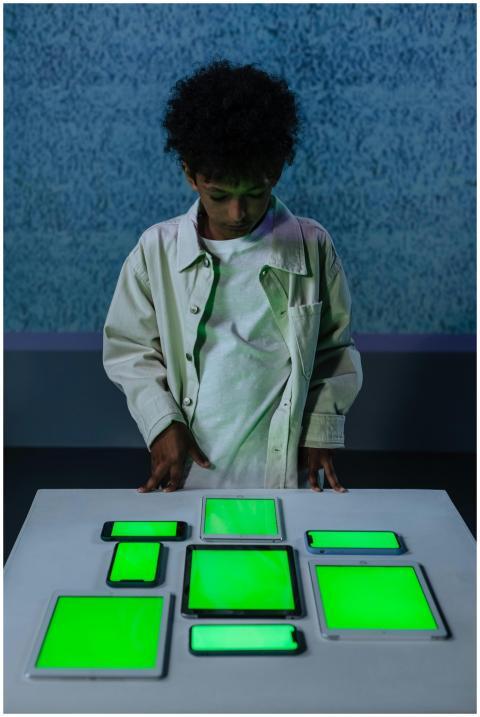 Young boy in studio with green screen gadgets on a