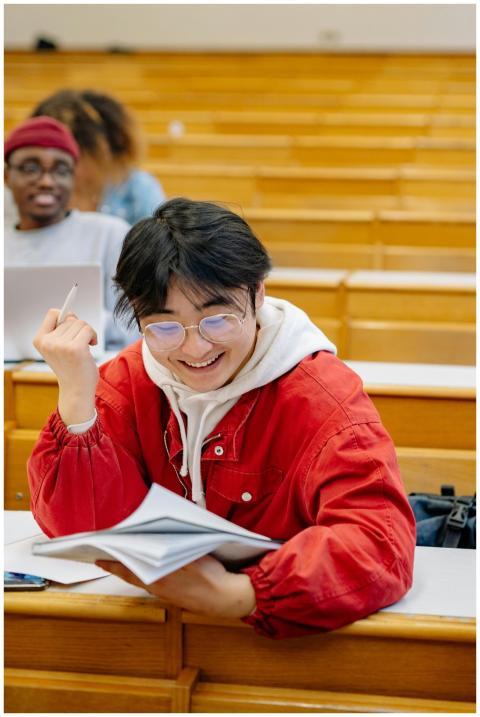A smiling student in a classroom setting, wearing