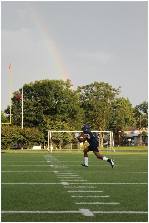 Athlete catching a pass on a football field with a