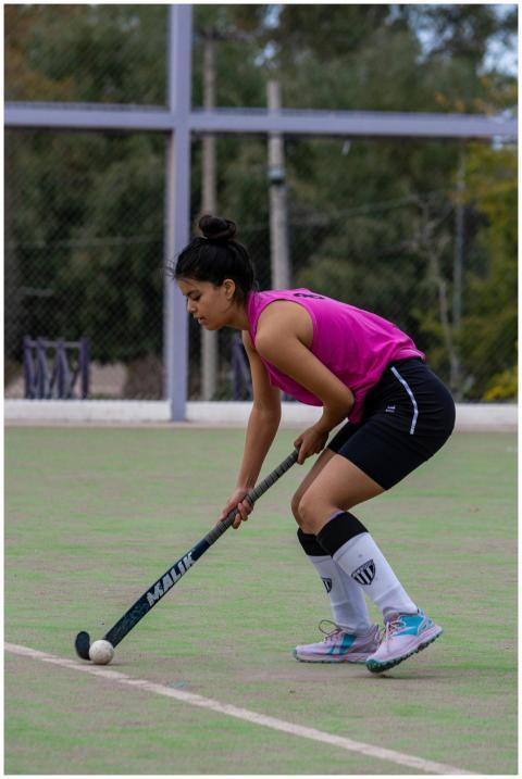 A young female athlete focuses on field hockey gam