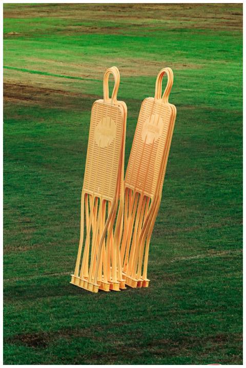 Two orange soccer training mannequins on a lush gr