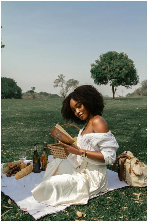A woman enjoys a serene picnic in a sunny park set