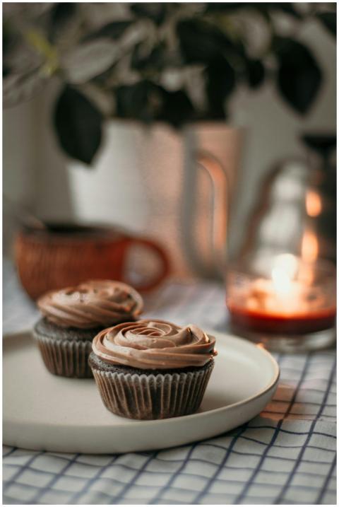 Delicious baked cupcakes in paper cups on plate pl