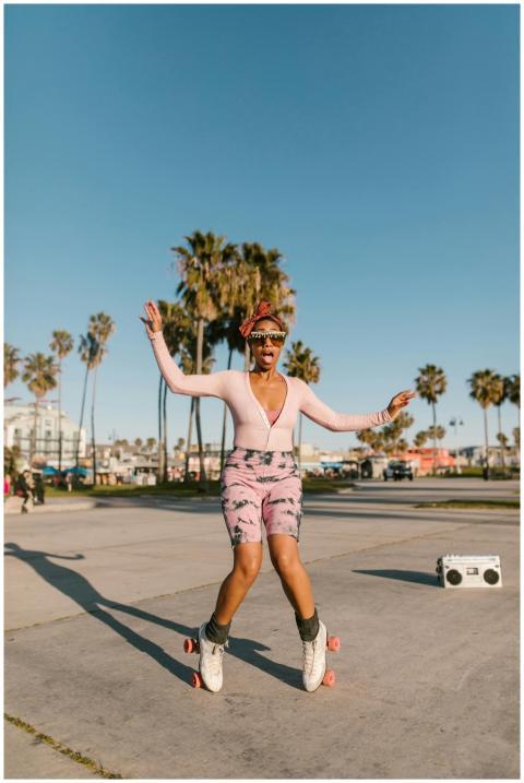Stylish woman roller skating at a beachside park w