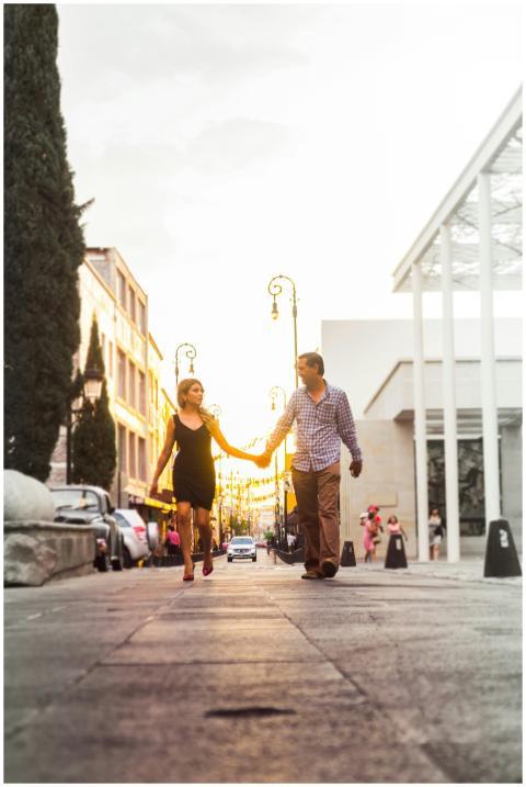 Couple walking hand in hand down an urban street a