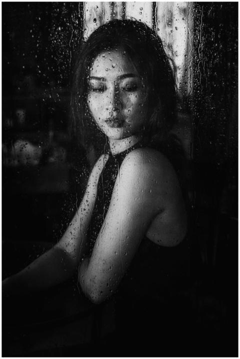 Monochrome portrait of a woman gazing through a ra