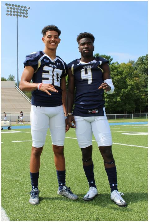 Two athletes in football uniforms pose on a sunny