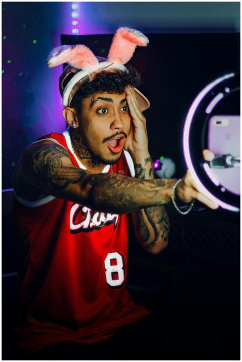 Young man posing indoors with rabbit ears and red